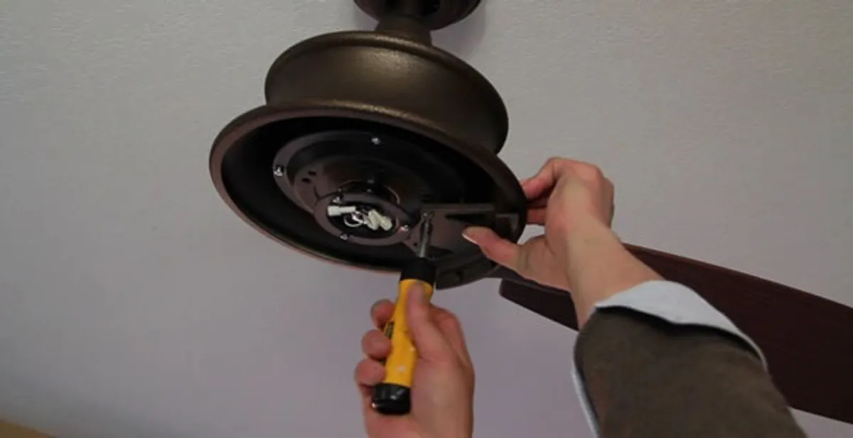 Electrician installing ceiling fan mounting bracket and fixture in New Orleans, LA