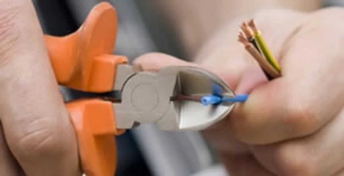 licensed electrician performing precise wire cutting and preparation during electrical service in New Orleans, LA